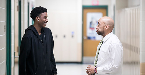 Photo of Anthony Bell talking with student
