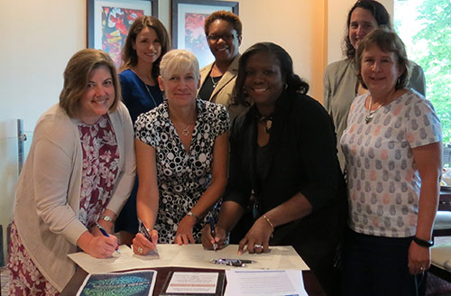 Staff from Alpha Phi Alpha Fraternity Inc., Kappa Phi Lambda Chapter and HCPSS signing partnership agreement