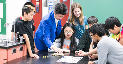 Sung Kim working with students in classroom