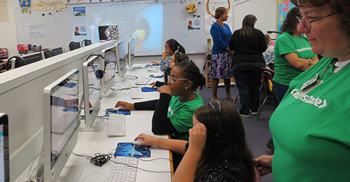 Female students in computer lab working on coding exercises.