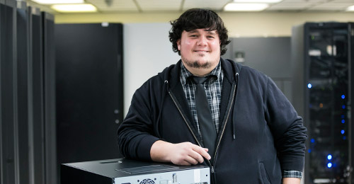 A proud Nick Vissari finishing a computer build in the server room