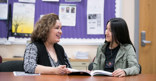 Lori Miller meeting with a student in a classroom